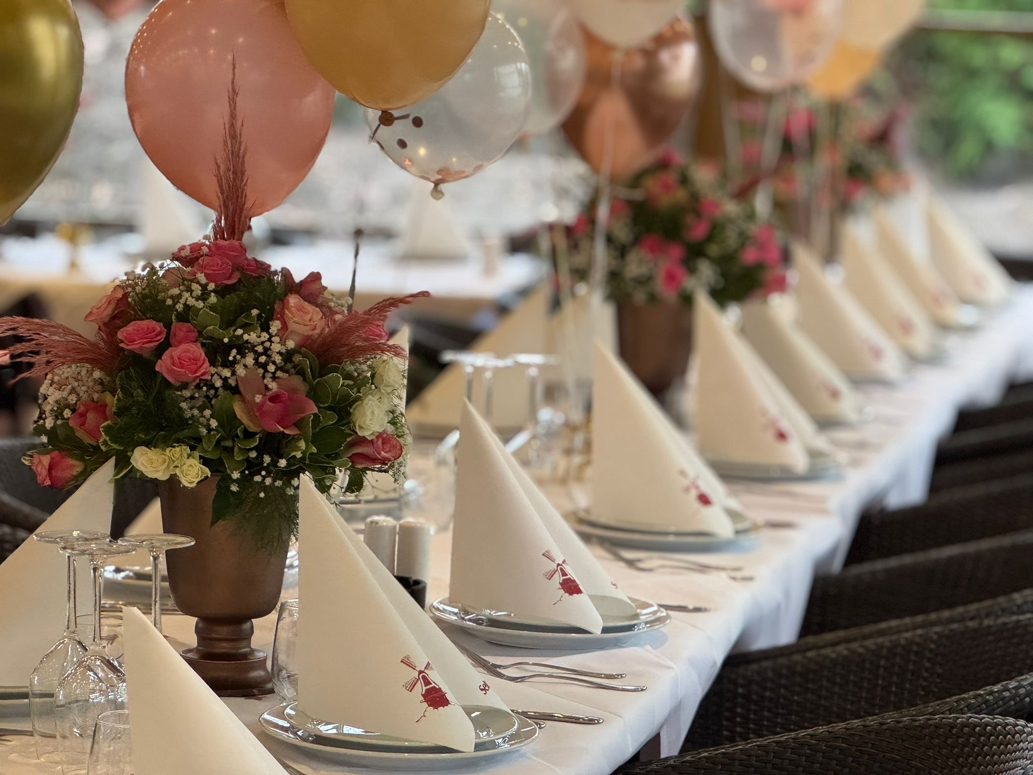 Festliche Tischdekoration mit Blumen und Luftballons